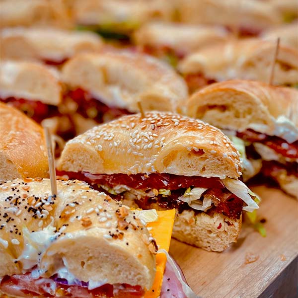 A large order of bagel sandwiches halved laid out.